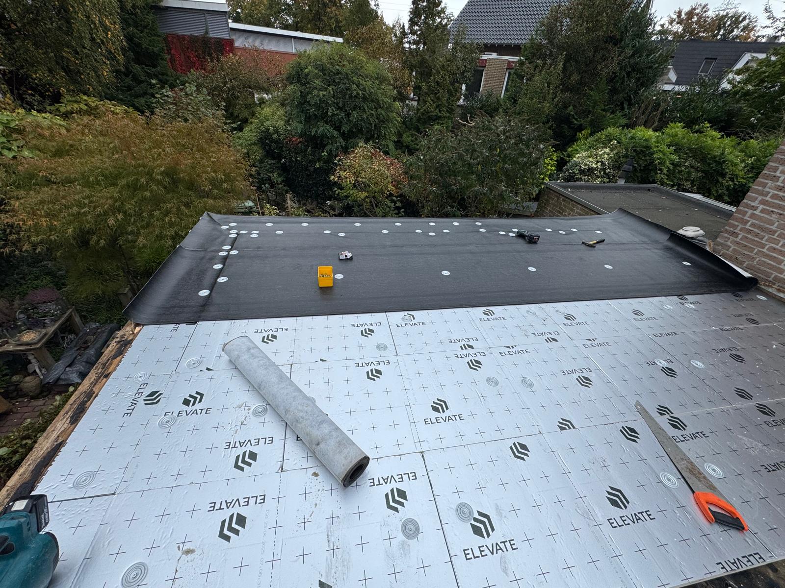 Nieuwe dakisolatieplaten op een plat dak met EPDM-dakbedekking die eroverheen wordt aangebracht